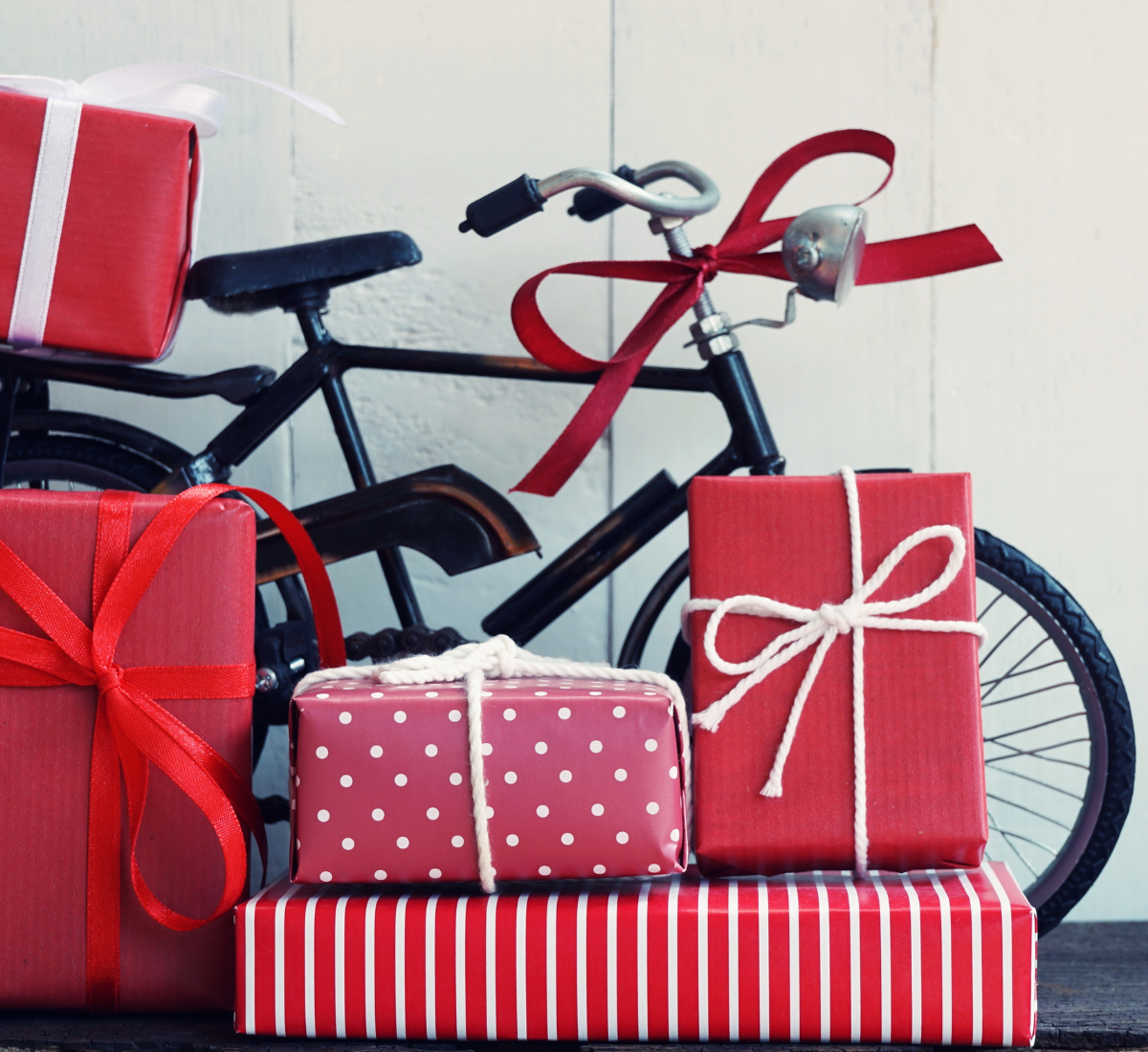 Vélo posé à côté de paquets cadeaux pour offrir du matériel outdoor au meilleur prix.